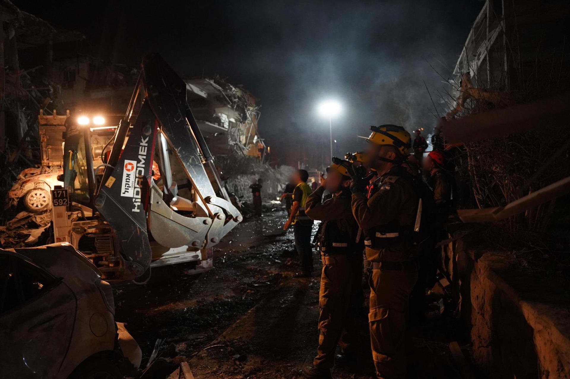 Fotografía cedida por las Fuerzas de Defensa de Israel (FDI) donde se observa a integrantes de los cuerpos de emergencia junto a un edificio destruido por un misil iraní este sábado, en Tel Aviv (Israel). EFE/ Fuerzas de Defensa de Israel / SOLO USO EDITORIAL/SOLO DISPONIBLE PARA ILUSTRAR LA NOTICIA QUE ACOMPAÑA (CRÉDITO OBLIGATORIO)