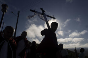 Fotografía de archivo fechada el 18 de abril de 2025 de un hombre sosteniendo una cruz, durante la tradicional procesión al santuario del Monte Santo en Bahía (Brasil). EFE/ Rafael Martins