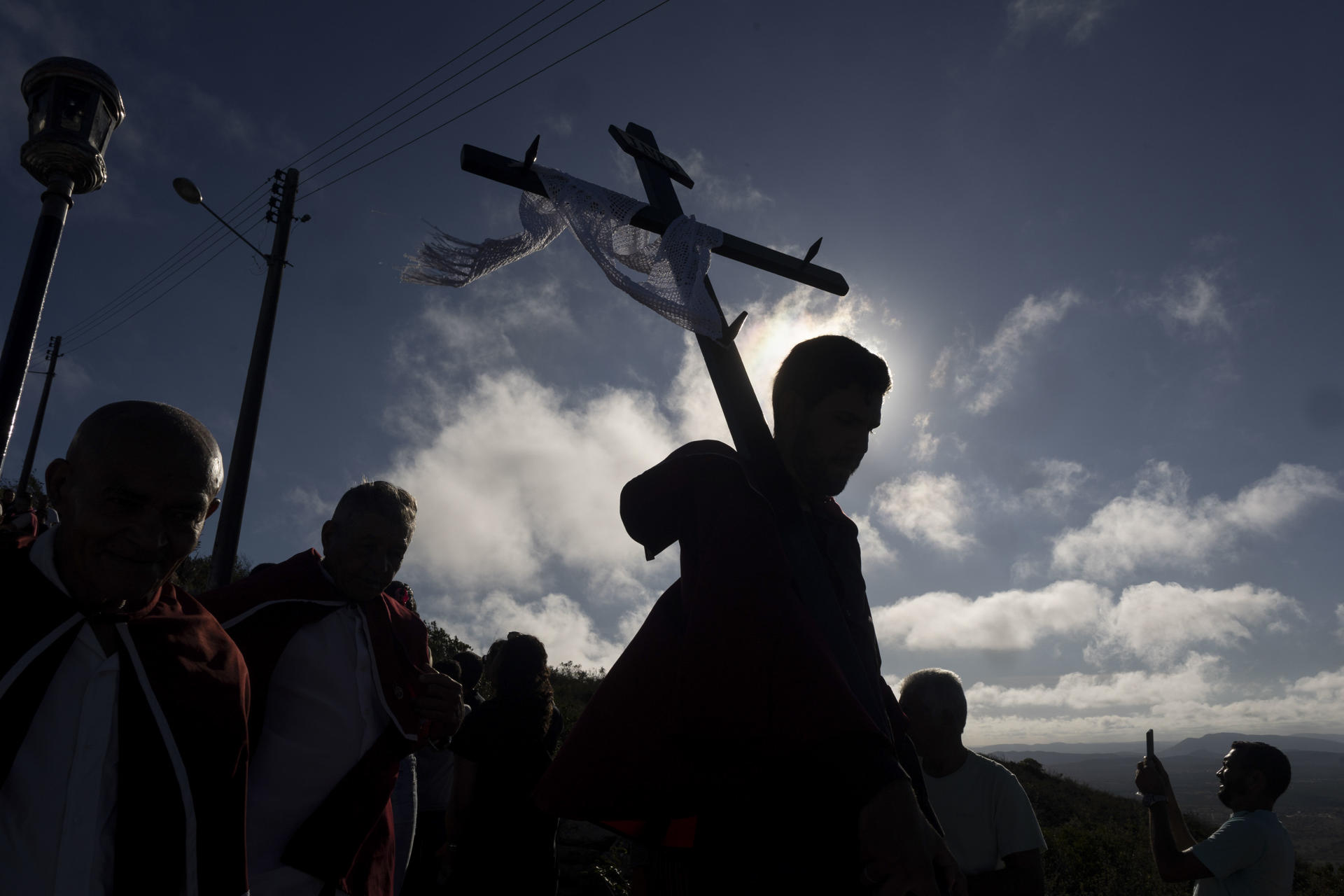 Fotografía de archivo fechada el 18 de abril de 2025 de un hombre sosteniendo una cruz, durante la tradicional procesión al santuario del Monte Santo en Bahía (Brasil). EFE/ Rafael Martins