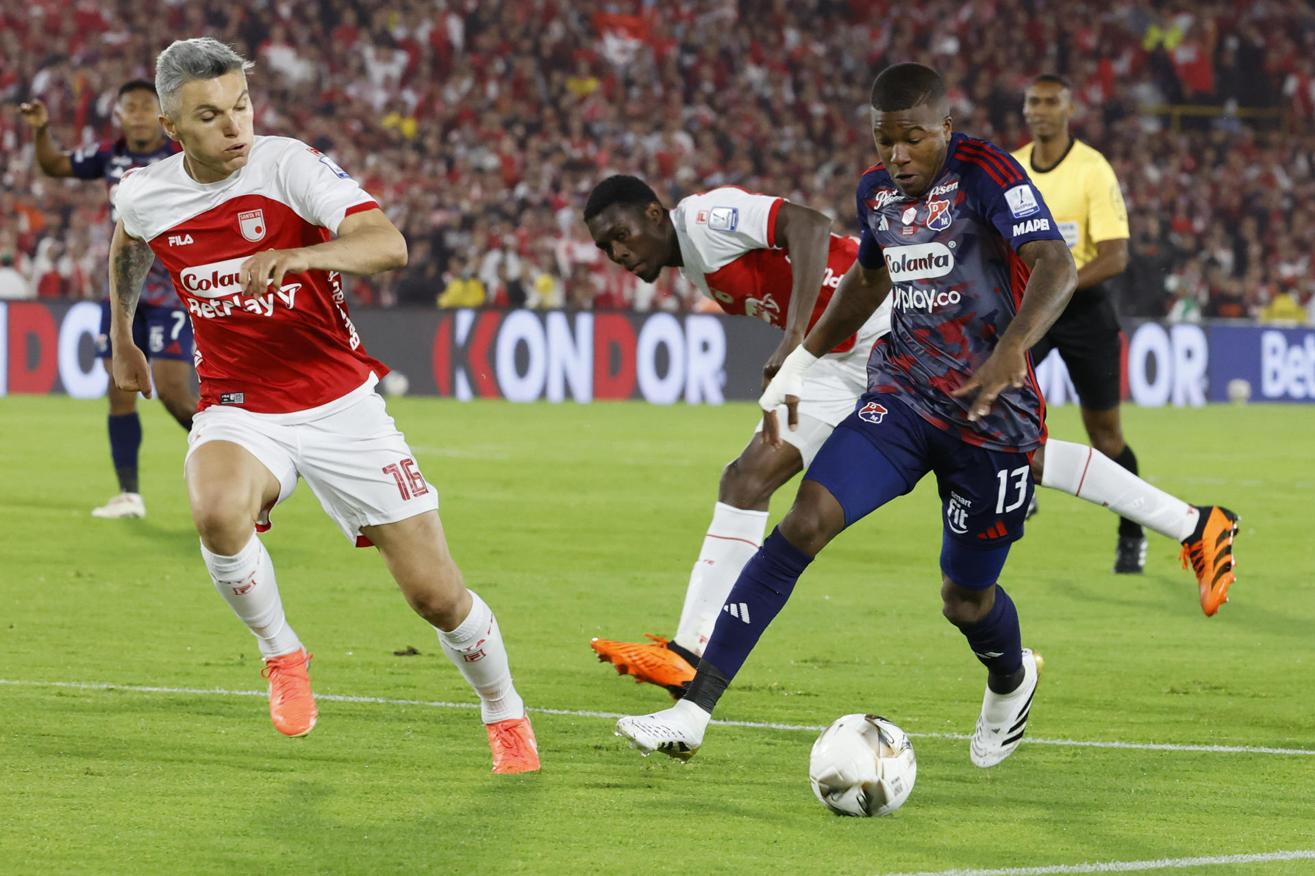 Daniel Torres (i) y Yilmar Velásquez (atrás), de Santa Fe, disputan un balón con Francisco Chaverra (d), de Medellín, durante el partido de ida de la final del la liga colombiana en el estadio El Campín en Bogotá (Colombia). EFE/ Mauricio Dueñas Castañeda