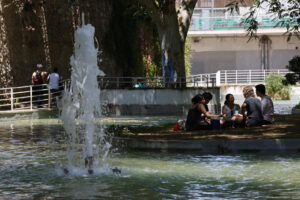 Unos jóvenes se reúnen bajo la sombra de un árbol y al lado de una fuente en el parque de la España Industrial en el barrio de Sants en Barcelona este domingo. Cataluña afronta este domingo el segundo día de la primera ola de calor de 2025, que en principio se prolongará hasta el martes, tras una noche tórrida que ha dejado una mínima de 30,4 grados en Portbou (Girona) y de 28 en Barcelona, según los registros del servicio Meteocat. Una ola de calor en la que ayer se registraron 46 grados en El Granado (Huelva), un hecho que nunca se había dado en el mes de junio, ha informado la Agencia Estatal de Meteorología (Aemet) este domingo. EFE/ Toni Albir