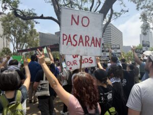 Fotografía del 9 de junio de 2025 que muestra a una persona que sostiene una pancarta durante una protesta contra las redadas migratorias en Los Ángeles (EE.UU.). EFE/ Alex Segura