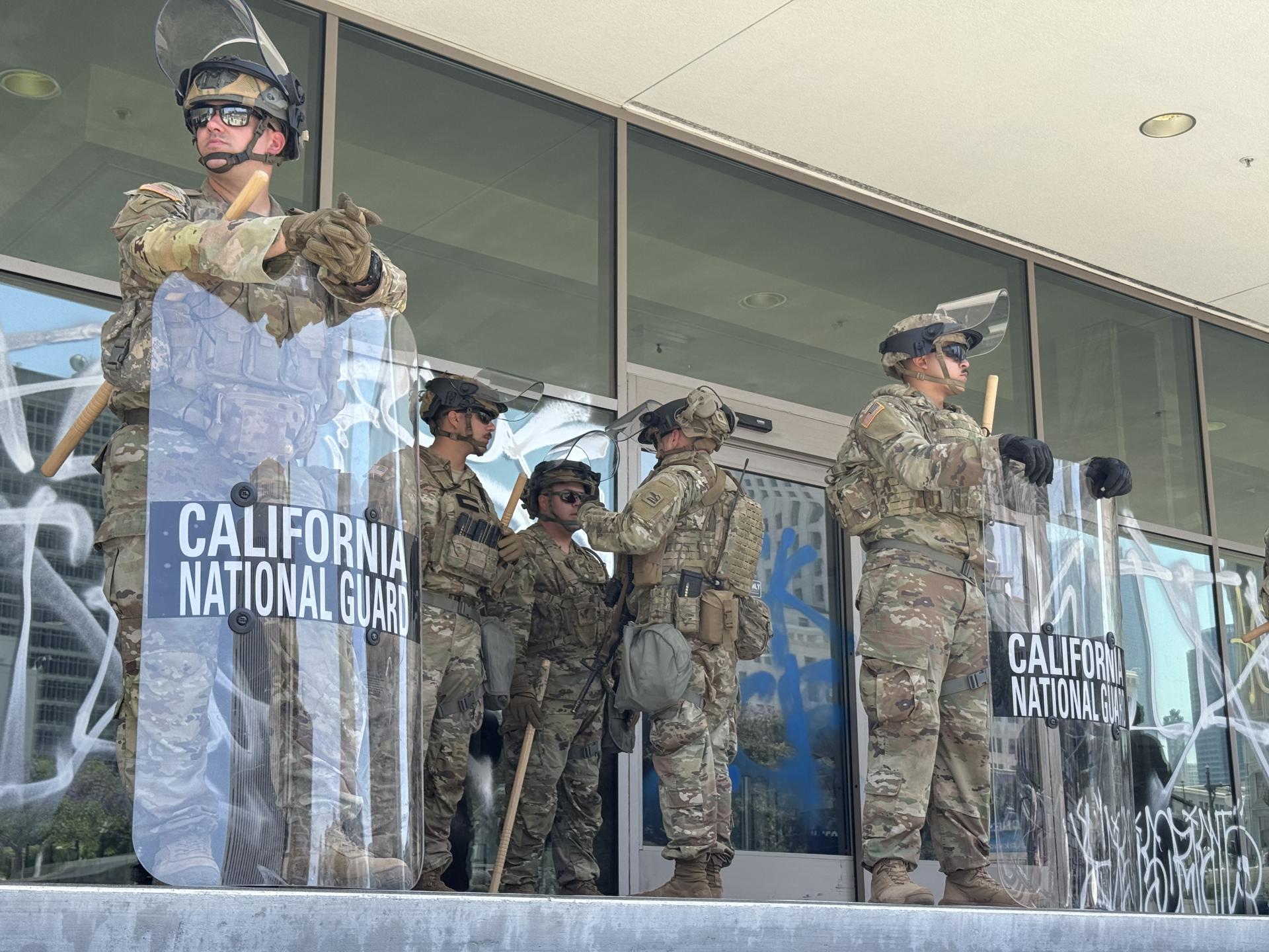 Integrantes de la Guardia Nacional de California esperan a la entrada de un edificio este lunes en el centro de Los Ángeles, California (EE.UU.). EFE/Alex Segura