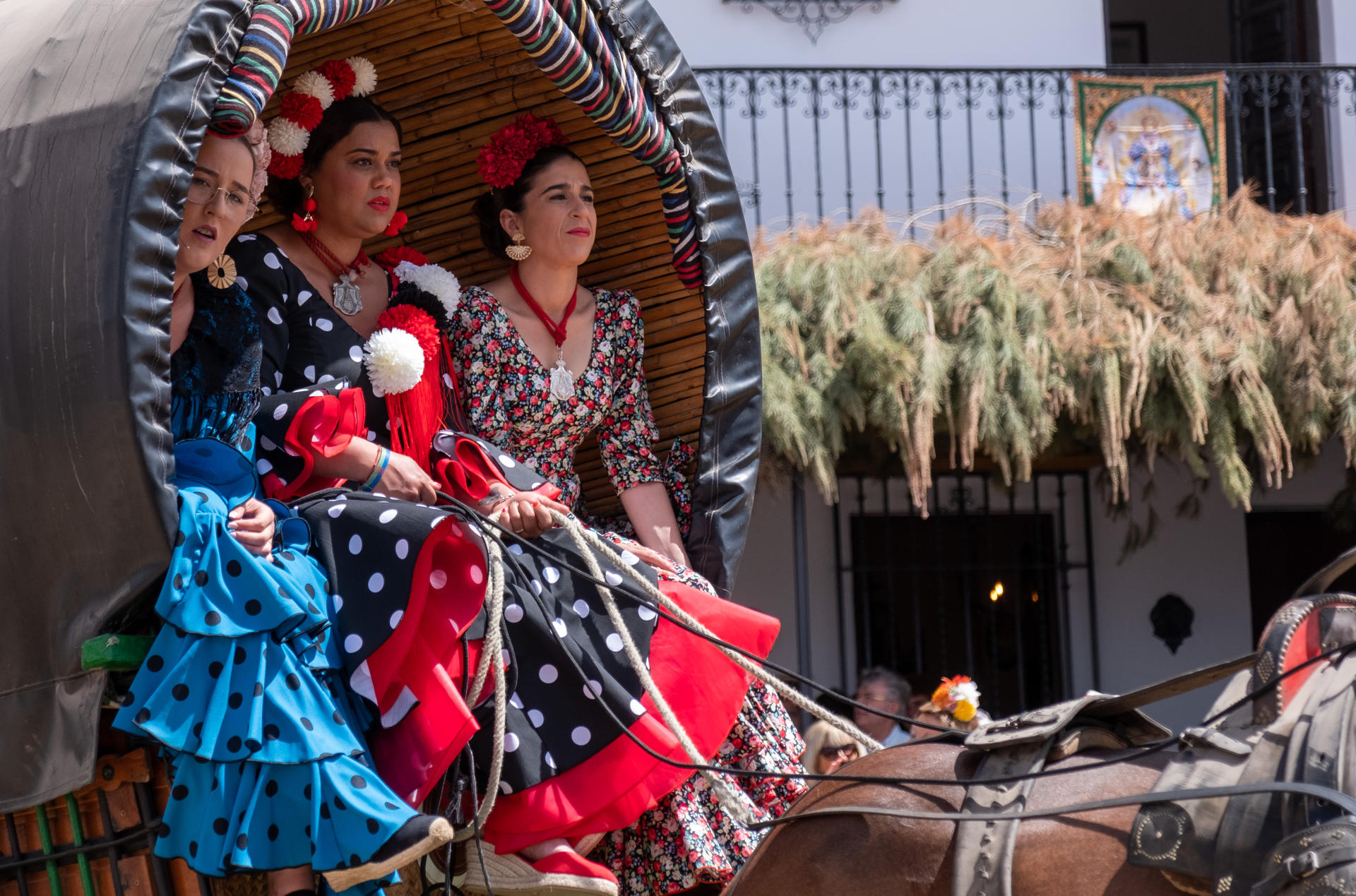 Imagen de archivo de tres mujeres de la Hermandad de Villamanrique de la Condesa (Sevilla) pasean subidas a un carro ante el Santuario de la Virgen del Rocío, en la aldea almonteña de El Rocío (Huelva). EFE/Julián Pérez