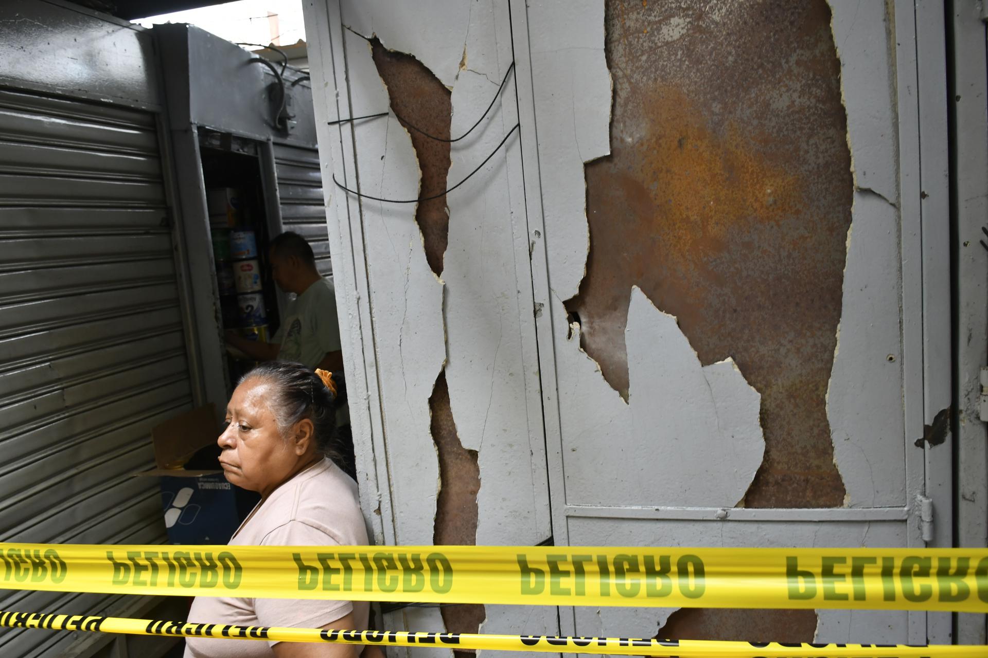 Una mujer espera este miércoles, junto a los daños causados por una explosión registrada la noche anterior en la zona comercial de La Bahía, en Guayaquil (Ecuador). EFE/ Jonathan Miranda