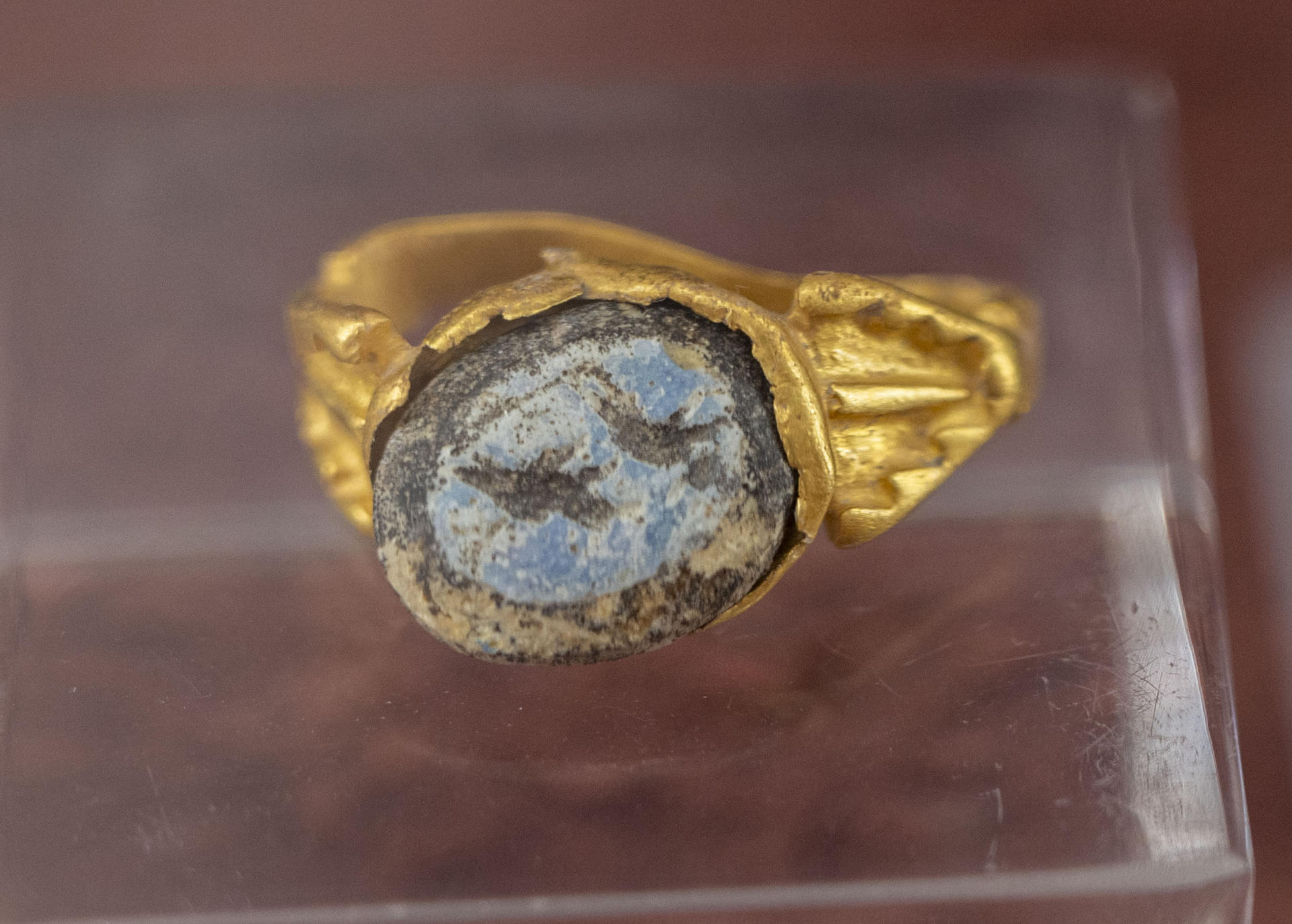 Un anillo de oro con una escena de caza en pasta vítrea, que forma de la muestra ‘Glíptica: gemas grabadas’, con una veintena de entalles hallados en el conjunto arqueológico de Cástulo, en Linares (Jaén), que proceden de la ciudad íbero romana grabadas en los siglos I y II y estarían vinculadas con las creencias de los moradores en torno a los dioses y las divinidades romanas, este miércoles en el Museo Arqueológico de Linares (Jaén). EFE/José Manuel Pedrosa