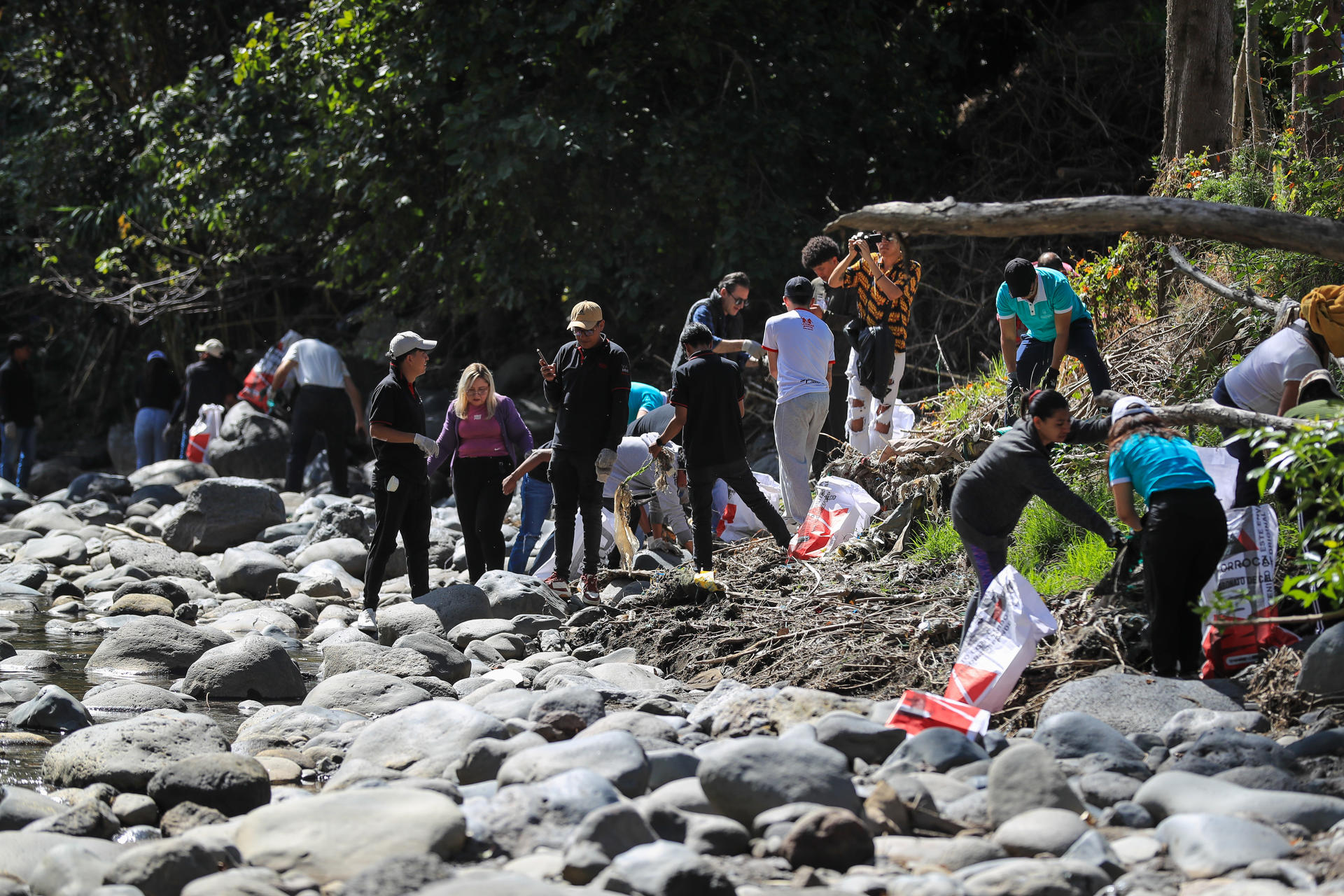 Decenas de personas fueron captadas este viernes, 20 de junio, durante una brigada de limpieza de materiales plásticos en el río San Pedro, liderara por el programa 'Galápagos Guardians', en Quito (Ecuador). EFE/José Jácome