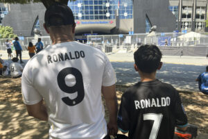 Personas posan con camisetas de Cristiano Ronaldo. EFE/Andrea Montolivo