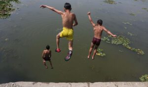 Niños saltan al agua en las afueras de Srinagar, Cachemira. EFE/EPA/FAROOQ KHAN