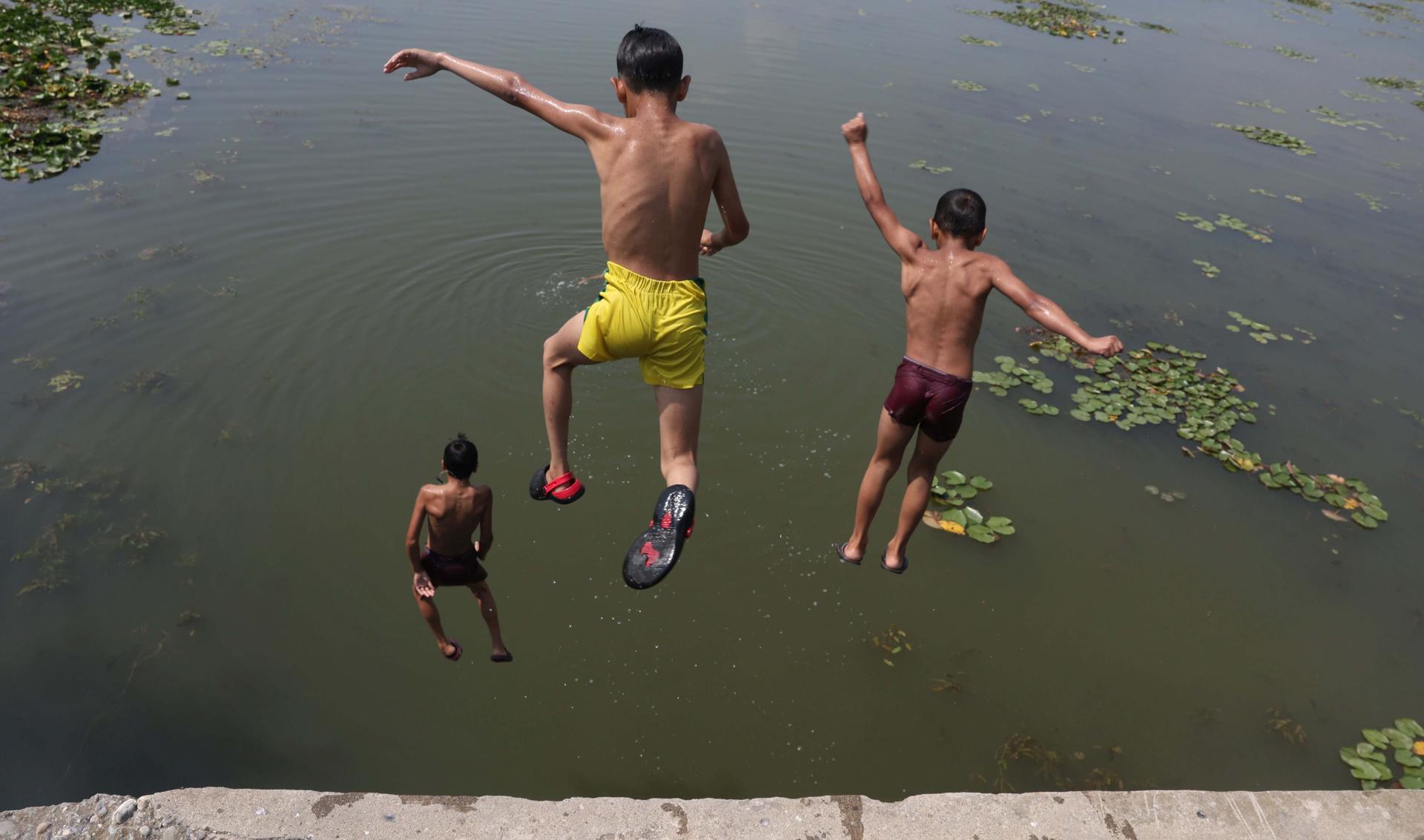 Niños saltan al agua en las afueras de Srinagar, Cachemira. EFE/EPA/FAROOQ KHAN