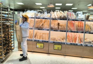 Una reponedora coloca barras de pan en las estanterías del obrador de un supermercado en el municipio madrileño de Las Rozas. EFE/Paloma Puente