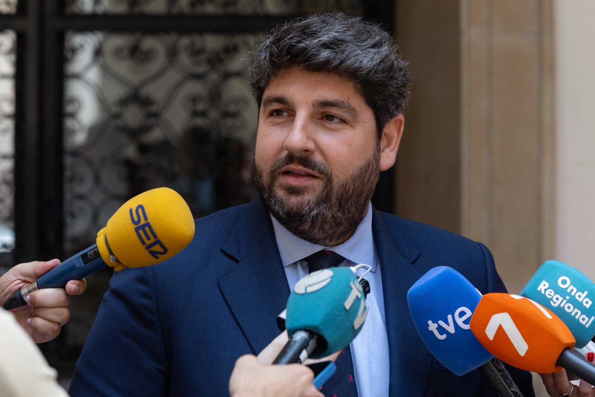 El presidente de la Comunidad de Murcia, Fernando López Miras (d), atiende a los medios de comunicación tras reunirse con los portavoces de los grupos parlamentarios en el parlamento murciano para abordar el techo de gasto y los presupuestos de la Comunidad Autónoma para 2025, este jueves en el Palacio de San Esteban. EFE/Marcial Guillén