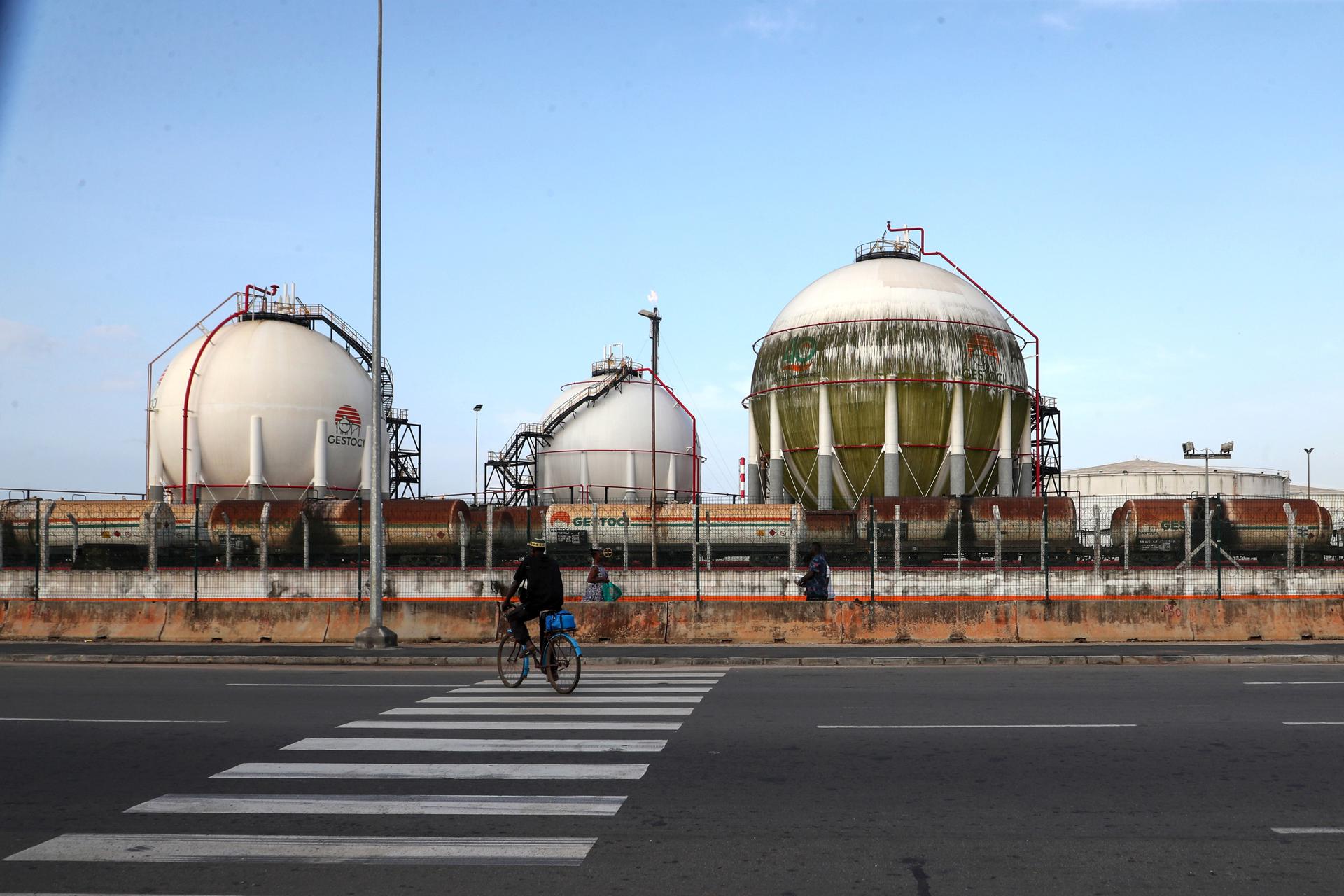 Un ciclista pasa por las instalaciones de la Sociedad Ivoriana de Refinado (SIR) en Abiyán, Costa de Marfil, 17 de junio de 2025. Las recientes escaladas militares entre Israel e Irán están generando temores de un posible cierre del estrecho de Ormuz, una vía fluvial crucial para el comercio mundial de petróleo y gas, lo que podría impactar significativamente en los mercados energéticos mundiales, provocando un fuerte aumento de los precios del petróleo. (Costa de Marfil) EFE/EPA/LEGNAN KOULA