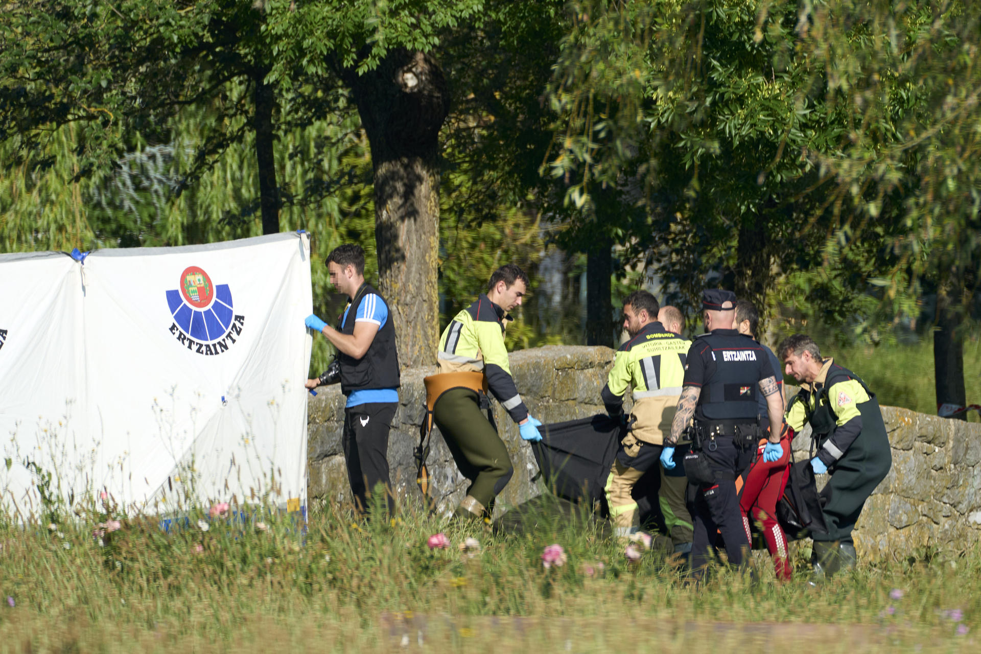 Bomberos, acompañados por miembros de la Ertzaintza, retiran el cadáver de un hombre hallado alrededor de las siete de la mañana de este martes flotando en un estanque del parque de San Martín de Vitoria. EFE/ L. Rico