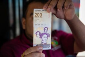 Fotografía de archivo de un hombre mostrando un billete de doscientos bolívares, en Caracas (Venezuela). EFE/ Ronald Peña