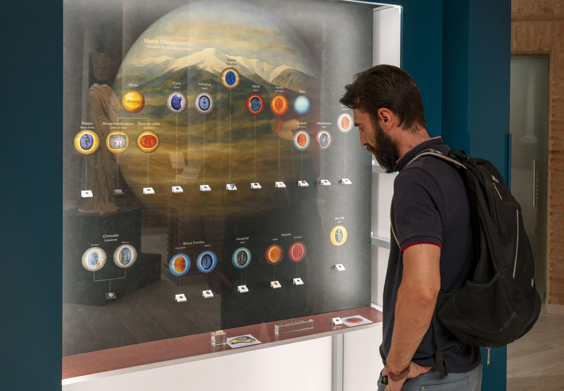 Una persona observa parte de la muestra ‘Glíptica: gemas grabadas’, con una veintena de entalles hallados en el conjunto arqueológico de Cástulo, en Linares (Jaén), que proceden de la ciudad íbero romana grabadas en los siglos I y II y estarían vinculadas con las creencias de los moradores en torno a los dioses y las divinidades romanas, este miércoles en el Museo Arqueológico de Linares (Jaén). EFE/José Manuel Pedrosa