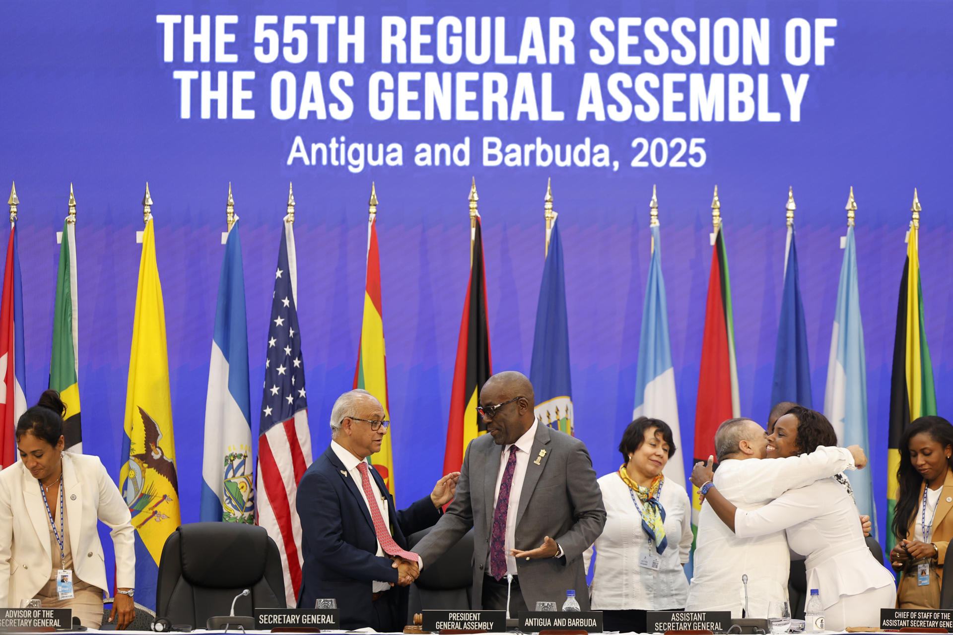 El secretario general de la Organización de Estados Americanos (OEA), Albert Ramadin (c-i), y el ministro de Exteriores de Antigua y Barbuda, Paul Chet Greene (c-d), al estrecharse la mano, al final de la 55ª Asamblea General de la OEA, en Saint John’s (Antigua y Barbuda). EFE/Bienvenido Velasco