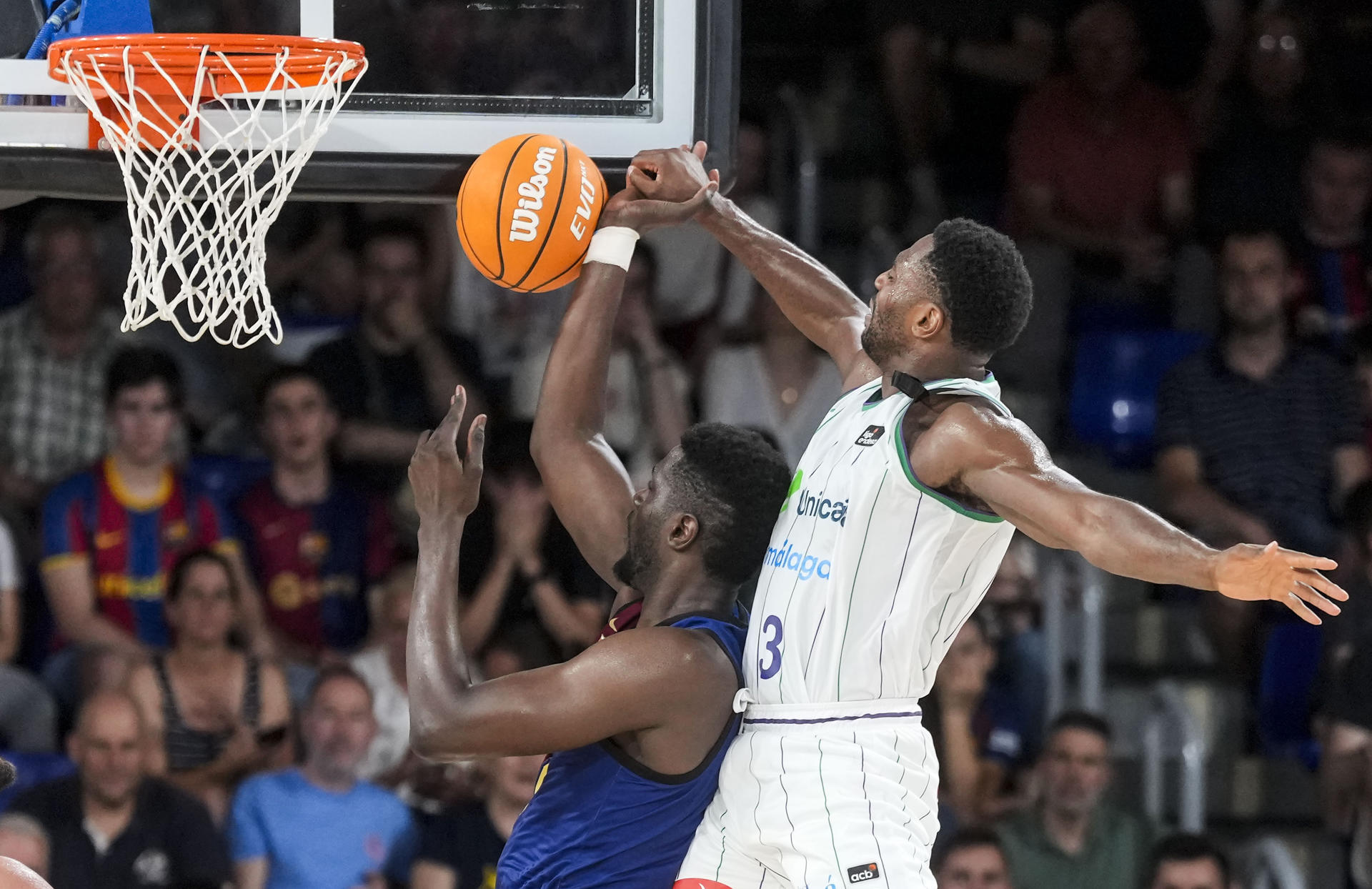 El alero de Unicaja Melvin Ejim, defiende el senegalés Youssoupha Fall, del Barça. EFE/ Enric Fontcuberta.