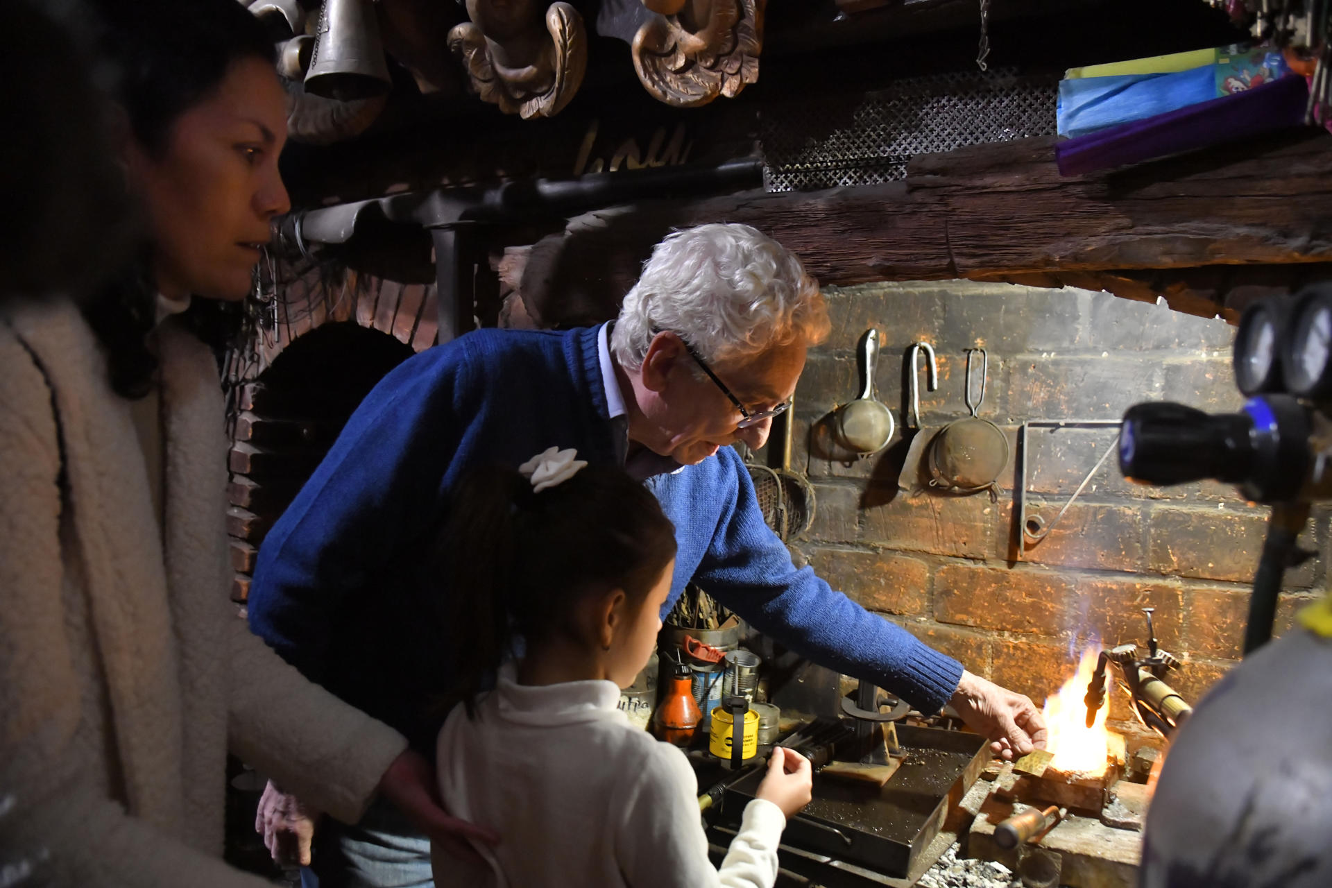 Fotografía del 30 de mayo de 2025 del orfebre Juan Carlos Pallarols (c) enseñando a una niña en su taller en el barrio San Telmo, en Buenos Aires (Argentina). EFE/ Enrique Garcia Medina