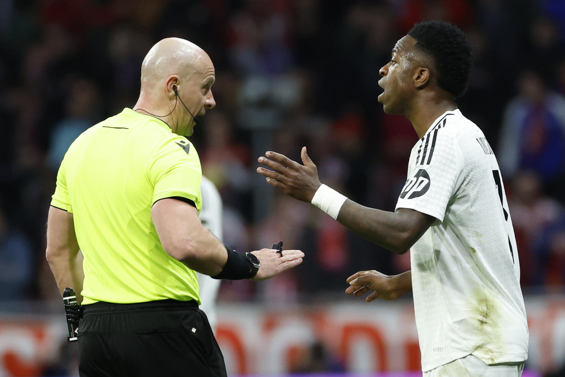 El delantero brasileño del Real Madrid Vinicius Jr. discute con el árbitro polaco Szymon Marciniak (i) en foto de archivo de Juanjo Martín. EFe