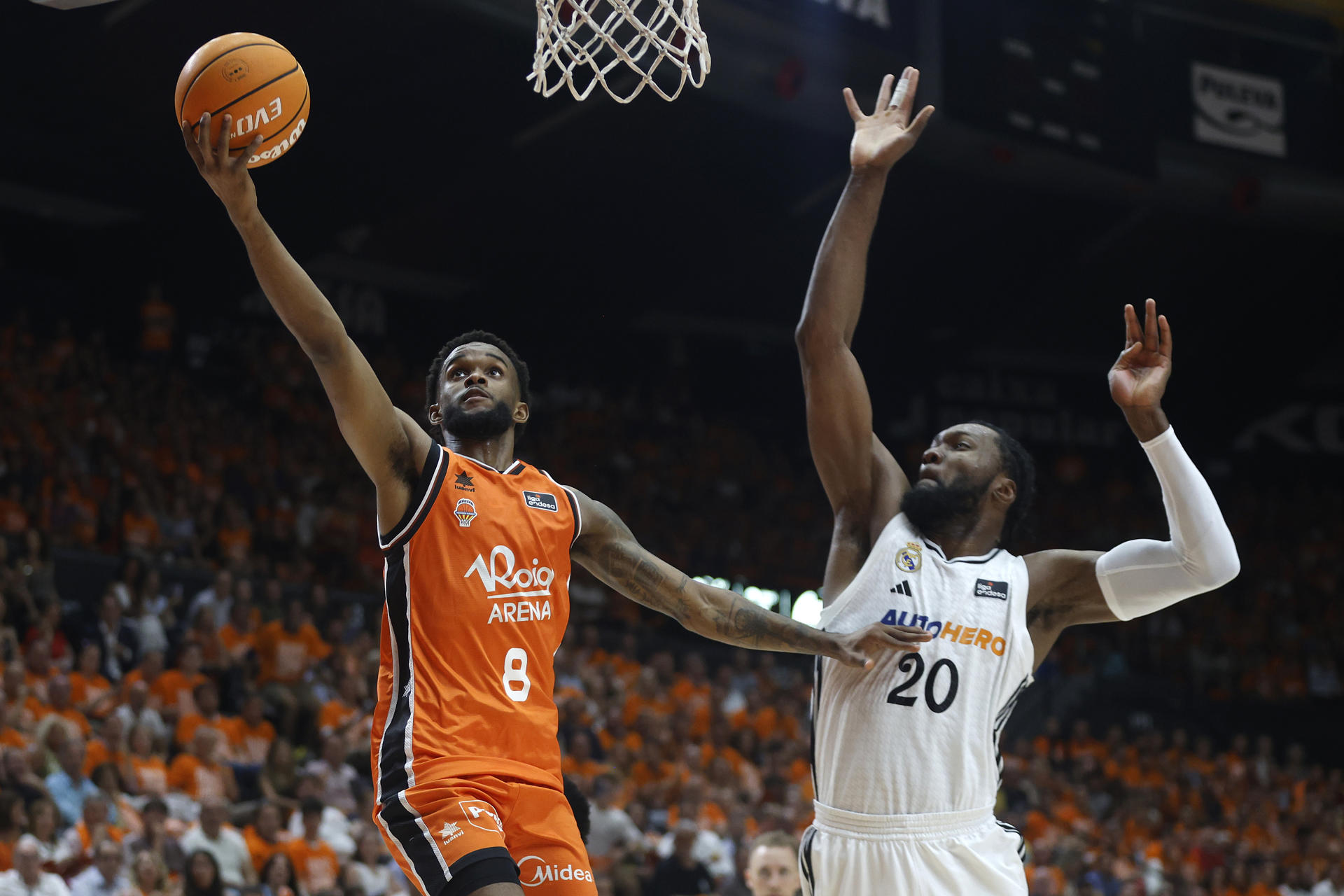 El escolta del Valencia Jean Montero (i) entra a canasta ante Bruno Fernando, del Real Madrid, durante el tercer partido de la final de la Liga Endesa que Valencia Basket y Real Madrid disputaron en el pabellón de la Fuente San Luis. EFE/Miguel Ángel Polo
