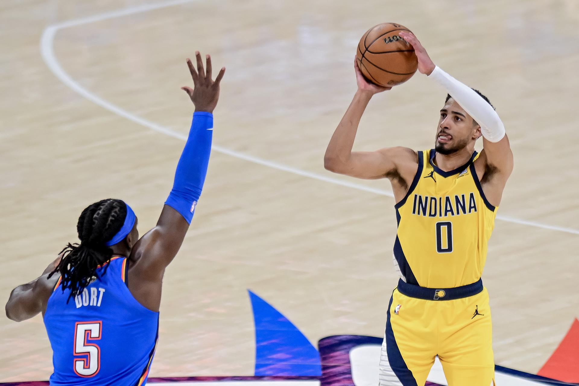 Tyrese Haliburton (d) de los Indiana Pacers lanza a la cesta con la marca de Luguentz Dort (i) de los Oklahoma City Thunder. EFE/Manuela Soldi