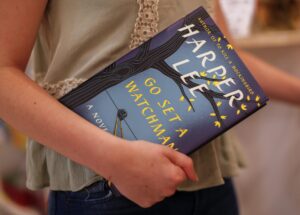 Imagen de archivo de una mujer con un ejemplar de la novela de Harper Lee "Ve y pon un centinela" publicada en 2015. EFE/ERIK S. LESSER