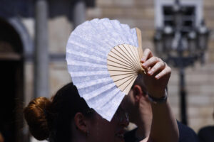 Una turista utiliza una sombrilla para protegerse del sol en Barcelona este sábado. Catorce comunidades están este sábado en alerta por temperaturas excepcionalmente altas en el día de inicio de la primera ola de calor del verano en España. EFE/Quique García
