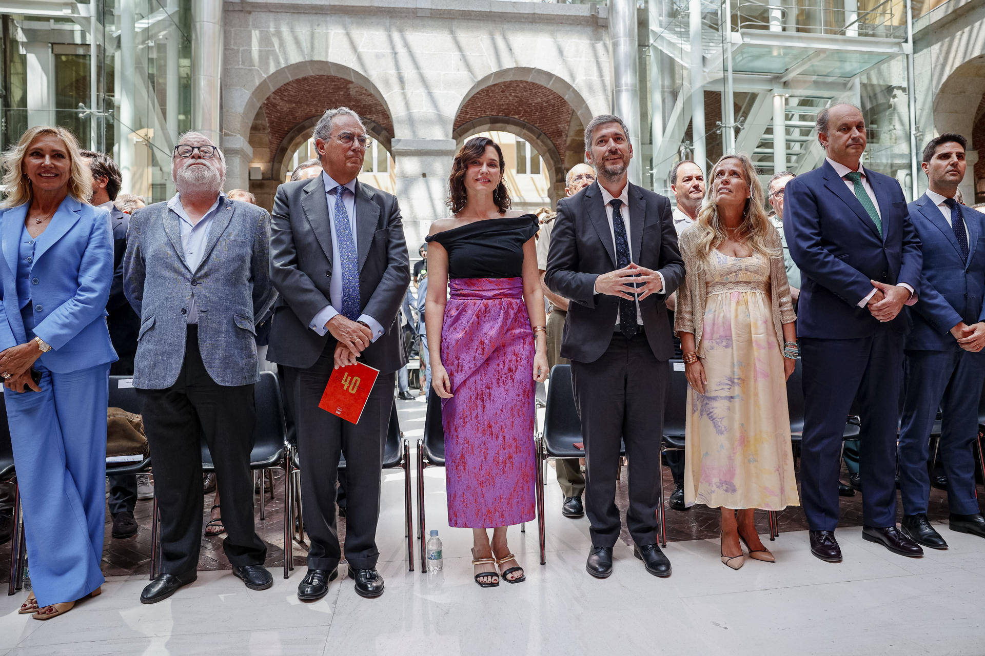 MLa presidenta de la Comunidad de Madrid, Isabel Díaz Ayuso, acompañada por el presidente de la Asamblea de Madrid, Enrique Ossorio (3i), la periodista Marta Robles (i), el escritor y filósofo (Fernando Savater), y los consejeros que formar parte del equipo de gobierno de Ayuso, Mariano de Paco (4d), Rocío Albert López, Miguel López Valverde (/2d) y Emilio Viciana, durante su intervención en el acto institucional por el 40 aniversario de la Real Casa de Correos. EFE/Daniel González