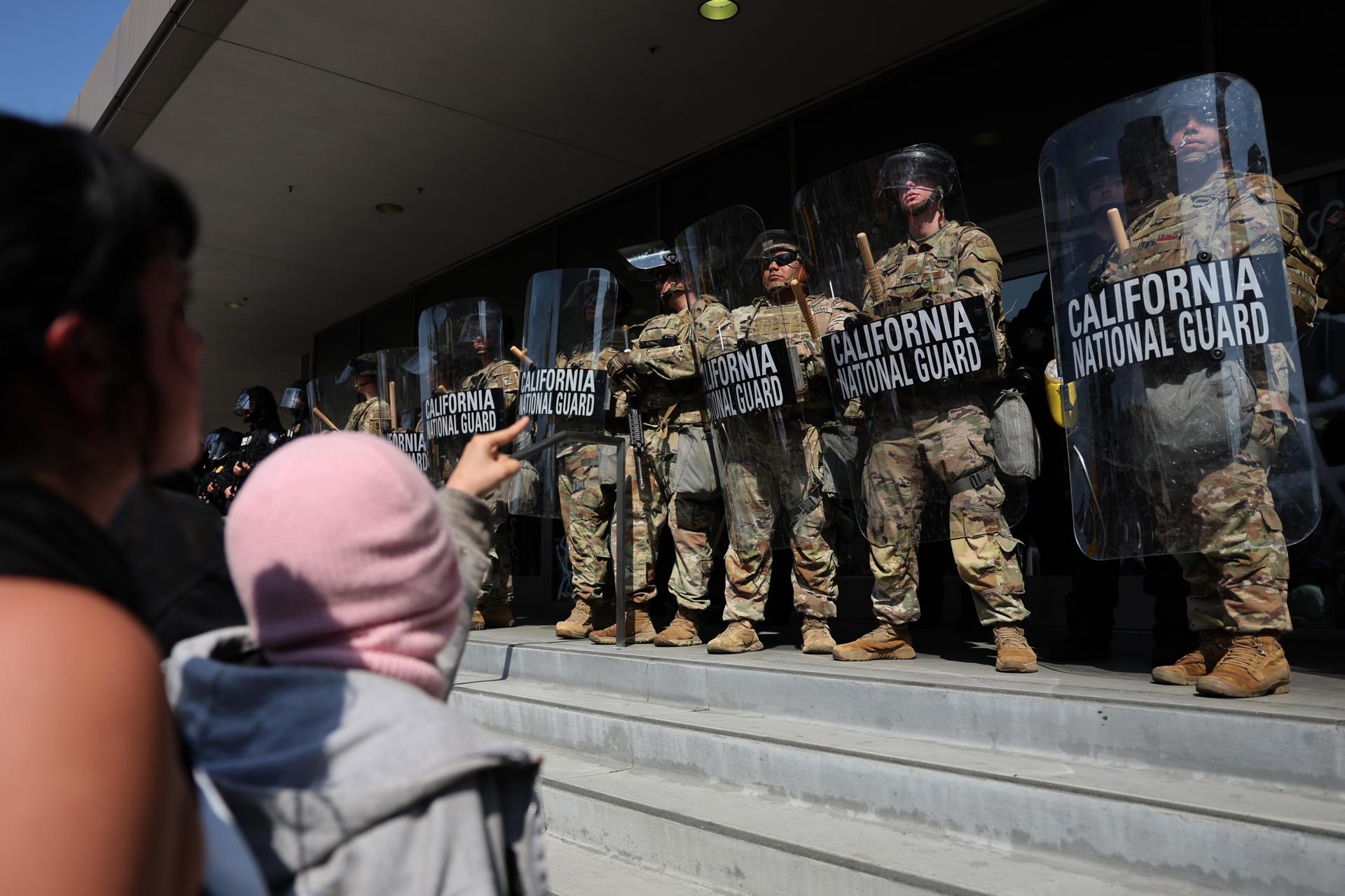 Varios manifestantes se manifiestan en frente de la Guardia Nacional que protege un edificio federal en Los Ángeles, California, Estados Unidos. EFE/ Allison Dinner