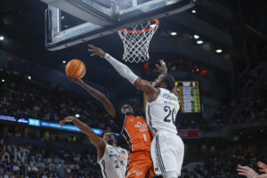 El escolta senegalés del Valencia Basket Brancou Badio (c) entra a canasta defendido por Bruno Fernando (d), del Real Madrid, durante el primer partido de la final de la Liga Endesa de baloncesto entre el Real Madrid y el Valencia Basket, este viernes en el Movistar Arena, en Madrid. EFE/ Juanjo Martín