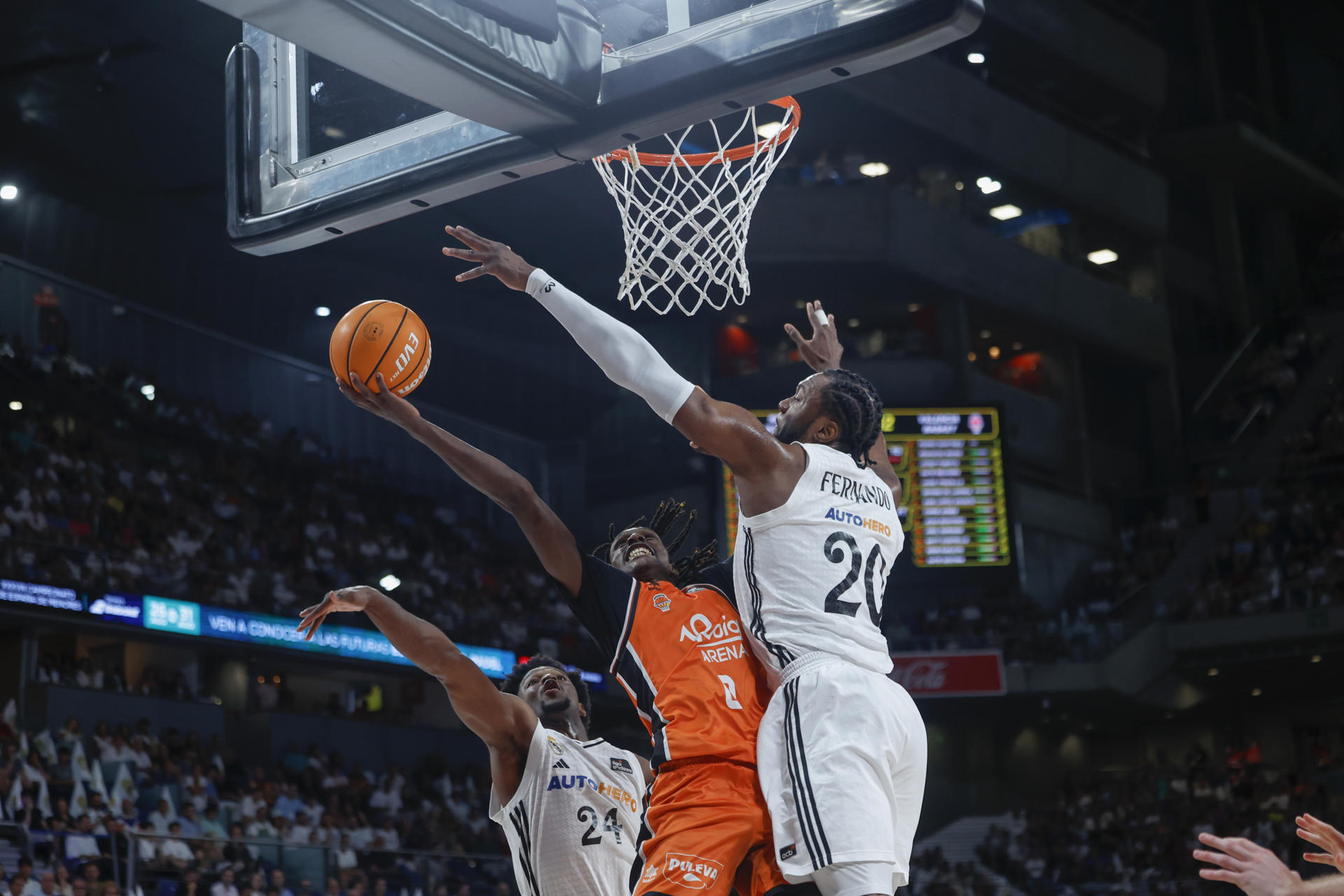 El escolta senegalés del Valencia Basket Brancou Badio (c) entra a canasta defendido por Bruno Fernando (d), del Real Madrid, durante el primer partido de la final de la Liga Endesa de baloncesto entre el Real Madrid y el Valencia Basket, este viernes en el Movistar Arena, en Madrid. EFE/ Juanjo Martín