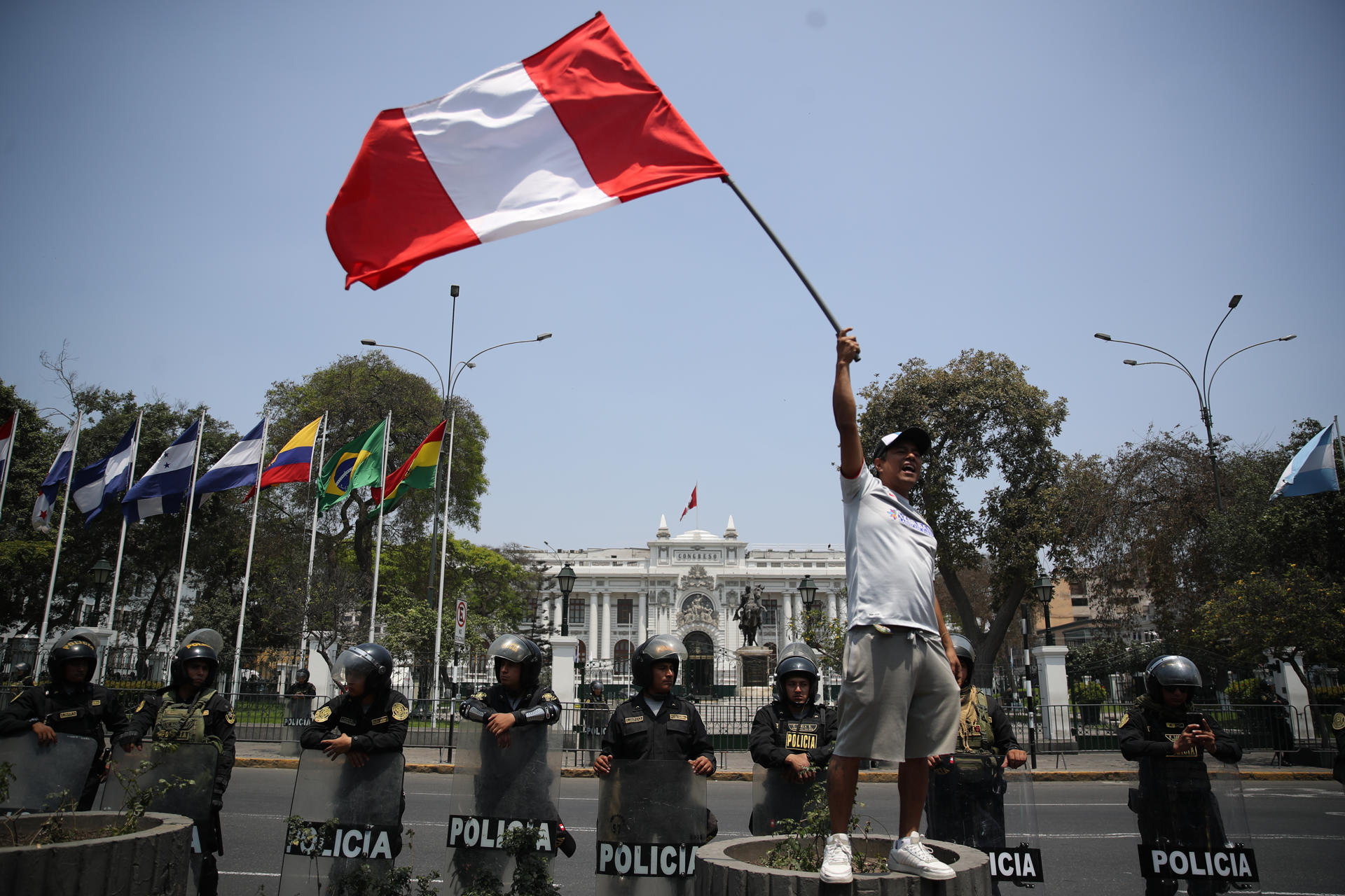 Fotografía de archivo de un hombre al ondear una bandera peruana, frente a la sede del Congreso Nacional de Perú, en Lima (Perú). EFE/Paolo Aguilar