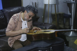 El nicaragüense Luis Enrique, reconocido como el 'Príncipe de la Salsa' firma una guitarra durante una entrevista con EFE este jueves, en Ciudad de Panamá (Panamá). Enrique dijo que a pesar de los rumores sobre la supuesta decadencia de la salsa, ocurre todo lo contrario: "La salsa sigue más viva que nunca". EFE/ Carlos Lemos