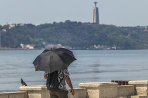 Una persona camina bajo un paraguas para protegerse del sol, este domingo en Lisboa, en Portugal. EFE EFE/EPA/ANTONIO COTRIM