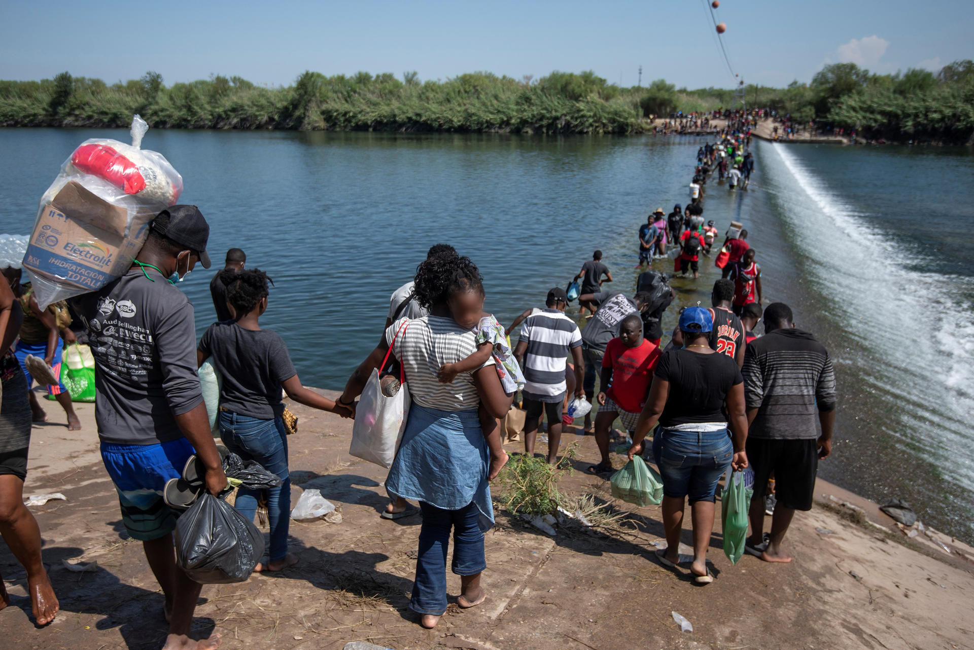 Fotografía de archivo de migrantes procedentes de Haití en el río Bravo cruzando rumbo a Estados Unidos, en Ciudad Acuña, (México).