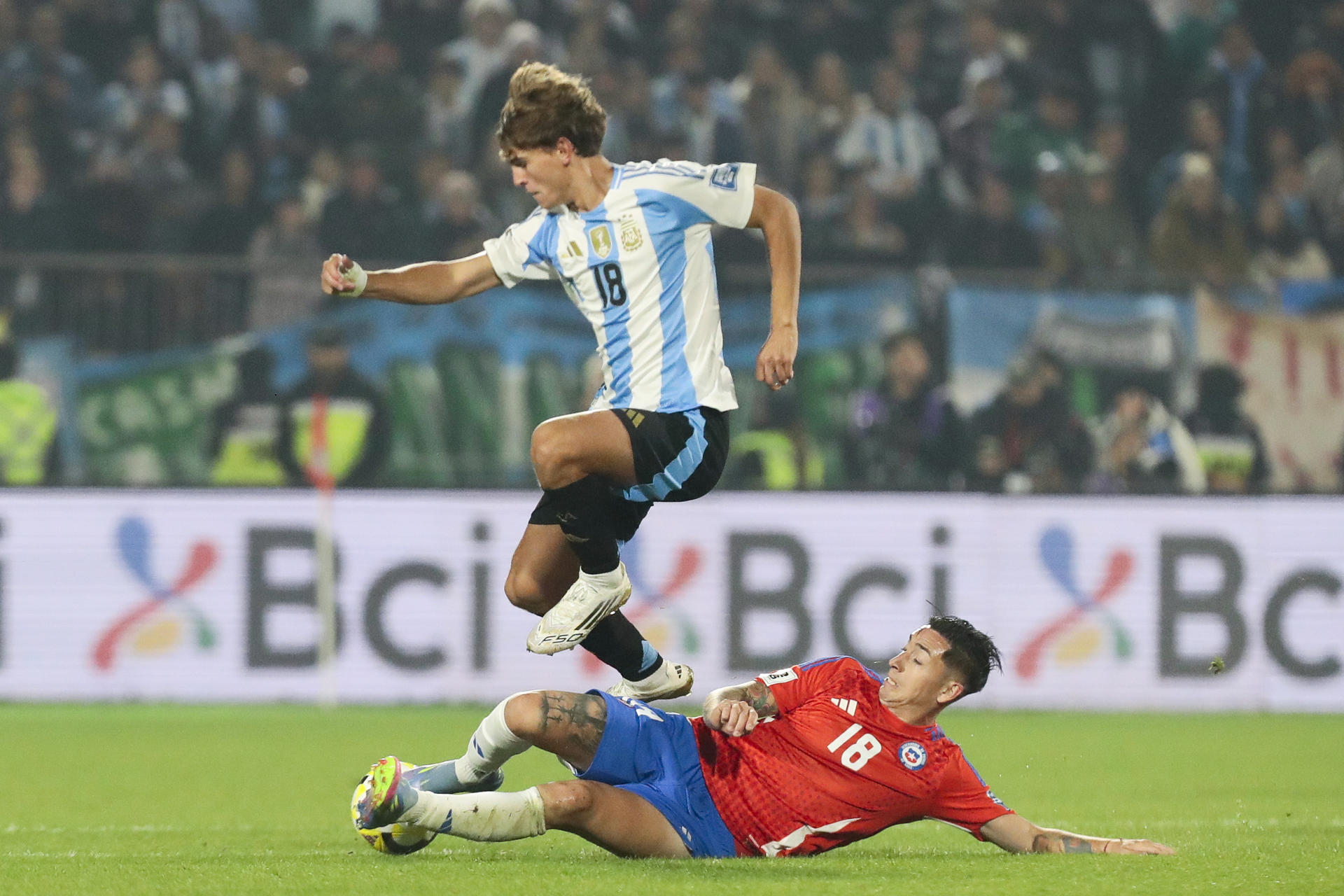 Rodrigo Echeverría (abajo), de Chile, disputa un balón con Nico Paz, de Argentina, durante un partido de las eliminatorias sudamericanas para el Mundial de 2026 entre las selecciones de Chile y Argentina en el estadio Nacional Julio Martínez Prádanos en Santigo (Chile). EFE/ Osvaldo Villarroel