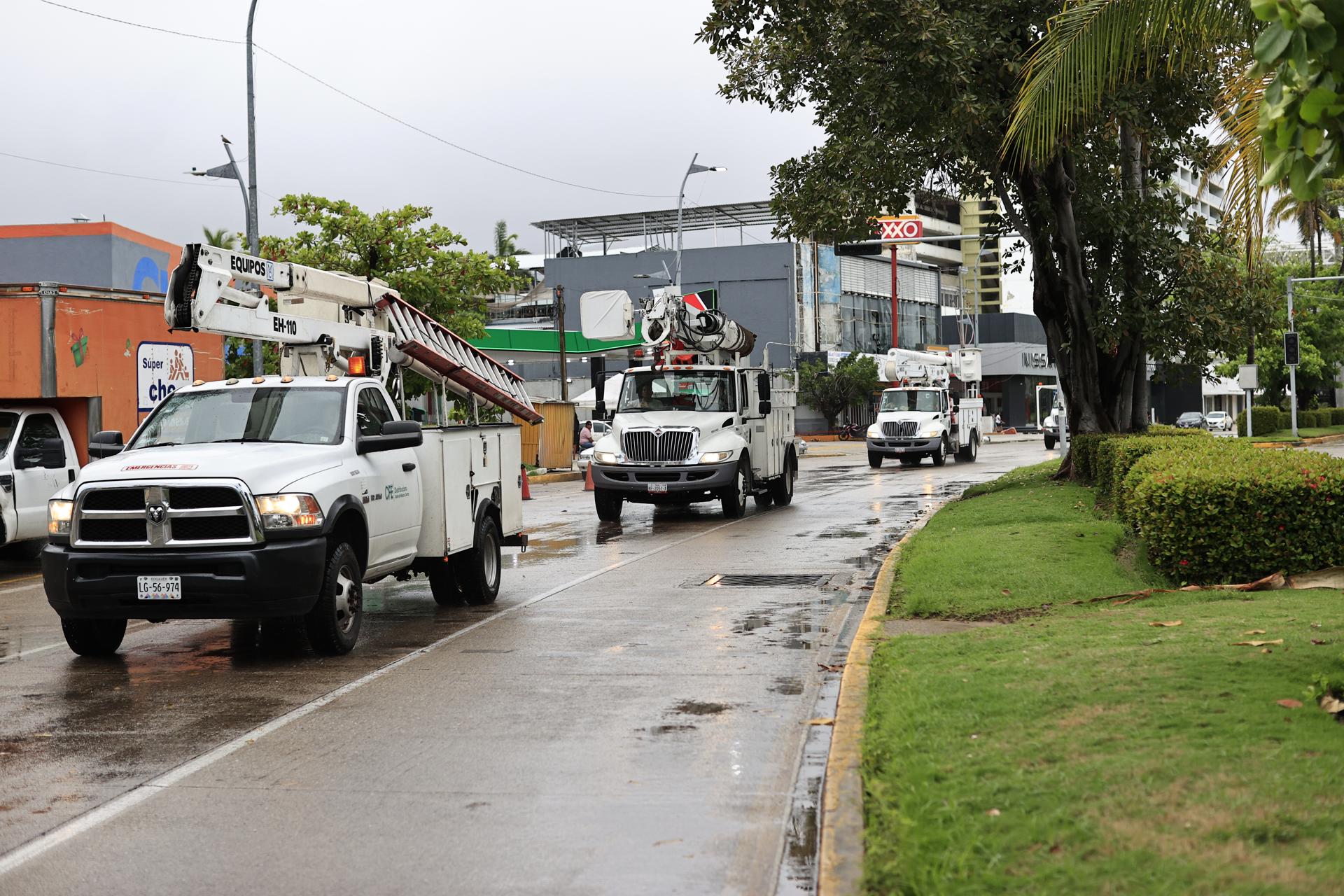 Integrantes de la Comisión Federal de Electricidad (CFE) hacen recorridos en vehiculos previo a la llegada del huracán Erick este jueves, en Acapulco (México). EFE/ David Guzmán