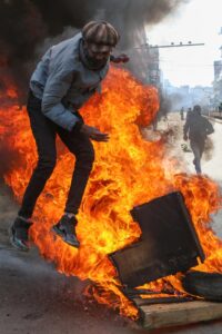 Un manifestante salta sobre neumáticos en llamas durante una protesta en el distrito central de negocios en Nairobi, Kenia, el 25 de junio de 2025, marcando el primer aniversario de las protestas de la Generación Z que culminaron con el asalto al parlamento nacional. (Protestas, Kenia) EFE/EPA/STR