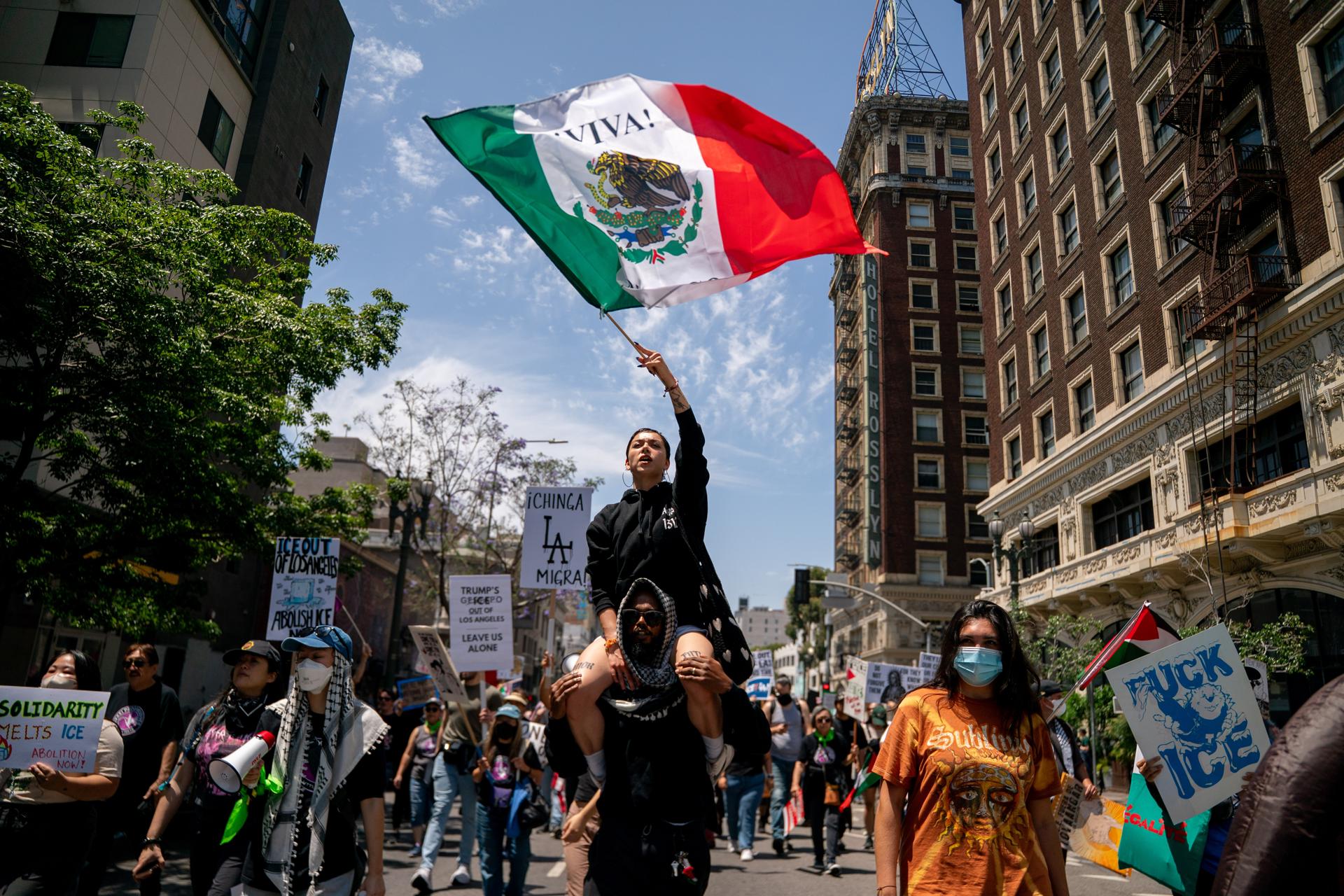 Un manifestante con la bandera de México durante la marcha en las calles del centro de Los Ángeles (EE.UU.) que congregó a miles de personas para expresar su indignación contra las políticas migratorias del presidente de Estados Unidos, Donald Trump. EFE/KYLE GRILLOT