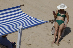Una mujer toma el sol en la playa de la Concha de San Sebastián. EFE/Juan Herrero