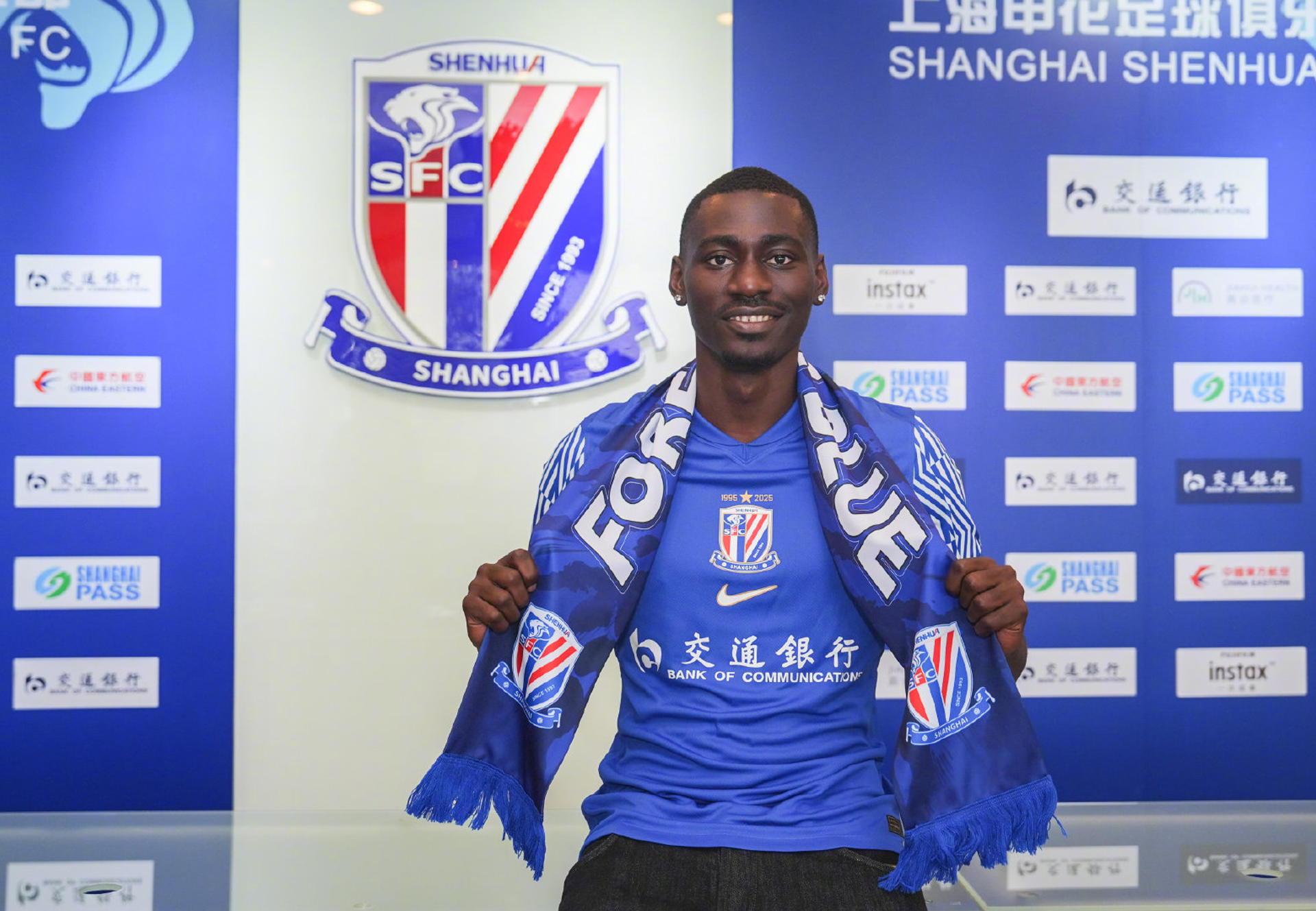 El delantero ecuatoguineano Luis Asué (i) posa con la camiseta de su nuevo equipo, el Shanghái Shenhua, durante su presentación oficial en Shanghái. Asué, de 23 años, se convierte en el primer futbolista de Guinea Ecuatorial en jugar en la Superliga china. EFE/Shanghái Shenhua  *****SOLO USO EDITORIAL/SOLO DISPONIBLE PARA ILUSTRAR LA NOTICIA QUE ACOMPAÑA (CRÉDITO OBLIGATORIO) *****