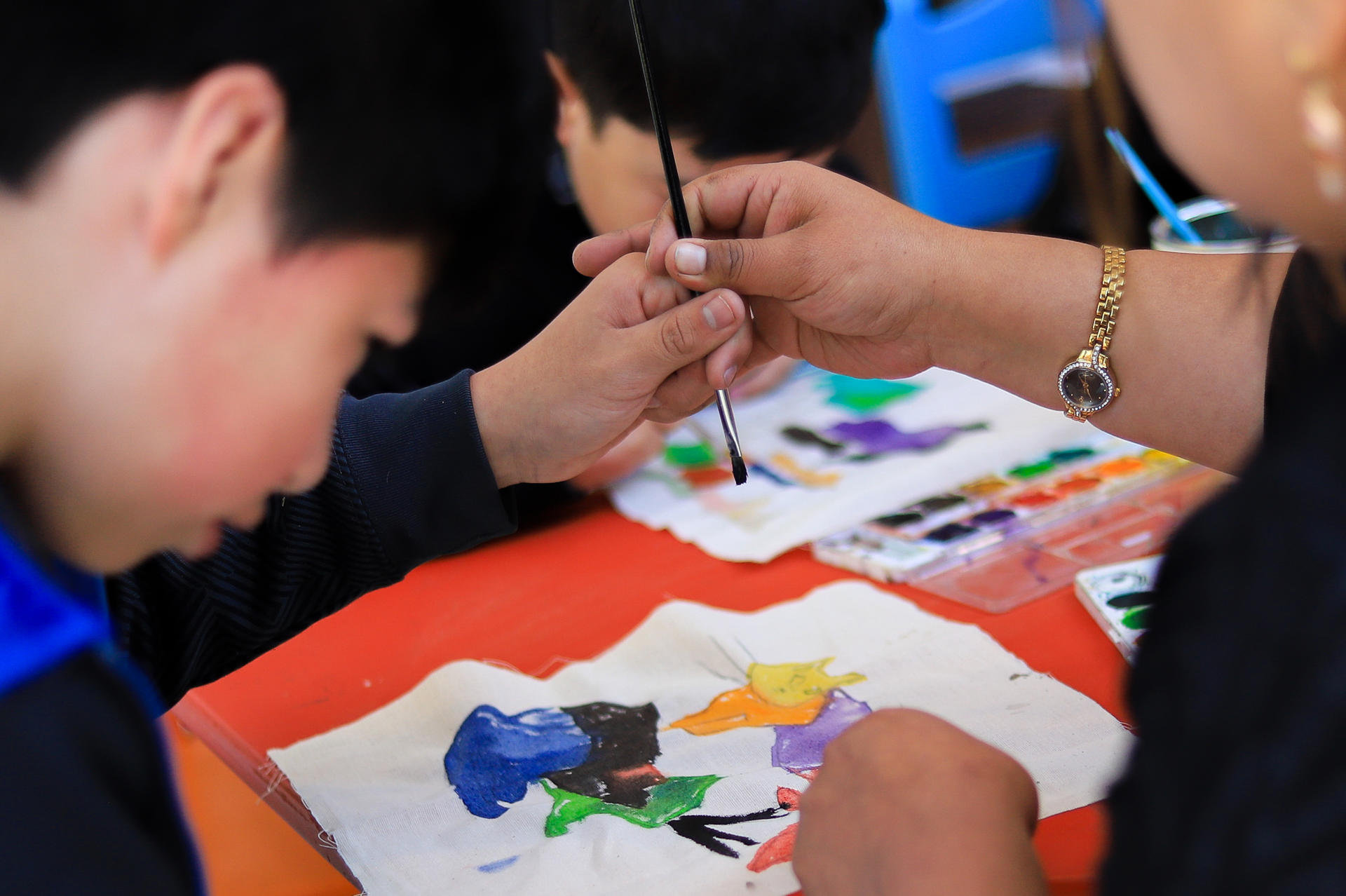 Una maestra guía la mano de un niño durante un taller inclusivo de pintura organizado por el Museo Nacional de Arte (MNA) en La Paz (Bolivia). EFE/ Gabriel Márquez