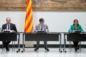El presidente catalán, Salvador Illa (c) junto al conseller de la Presidencia, Albert Dalmau (i) y la consellera de Territorio, Vivienda y Transición Ecológica y Portavoz del Govern, Silvia Paneque (d), durante la reunión de la Comisión técnica para la ampliación de la capacidad del aeropuerto de El Prat celebrada este martes en el Palau de la Generalitat, tras la que ha anunciado, que Aena invertirá 3.200 millones en la ampliación del Aeropuerto Josep Tarradellas Barcelona-El Prat, un proyecto que contempla extender la tercera pista, la más cercana al mar, en 500 metros. EFE/ Enric Fontcuberta