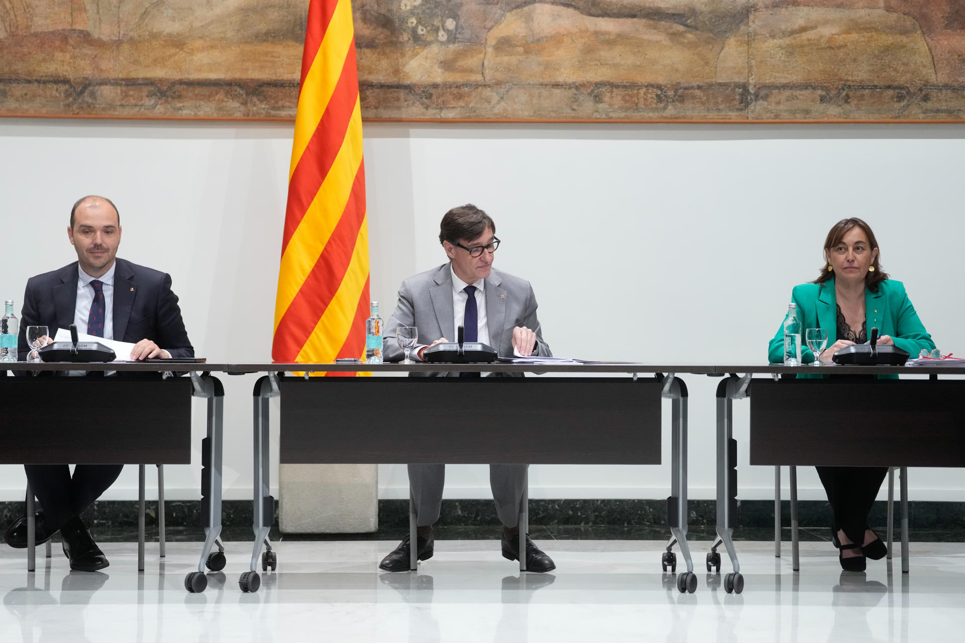 El presidente catalán, Salvador Illa (c) junto al conseller de la Presidencia, Albert Dalmau (i) y la consellera de Territorio, Vivienda y Transición Ecológica y Portavoz del Govern, Silvia Paneque (d), durante la reunión de la Comisión técnica para la ampliación de la capacidad del aeropuerto de El Prat celebrada este martes en el Palau de la Generalitat, tras la que ha anunciado, que Aena invertirá 3.200 millones en la ampliación del Aeropuerto Josep Tarradellas Barcelona-El Prat, un proyecto que contempla extender la tercera pista, la más cercana al mar, en 500 metros. EFE/ Enric Fontcuberta