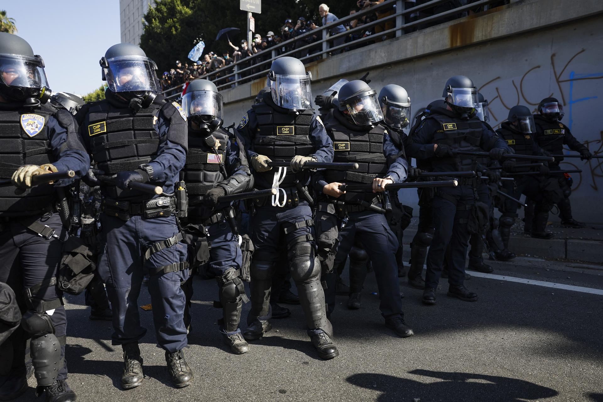 Agentes de policía fueron captados este domingo, 8 de junio, al avanzar para contener a cientos de activistas que protestan contra las redadas de inmigración, en la autopista 101 cerca del edificio federal Edward R. Roybal, en Los Ángeles (CA, EE.UU.). EFE/Caroline Brehman