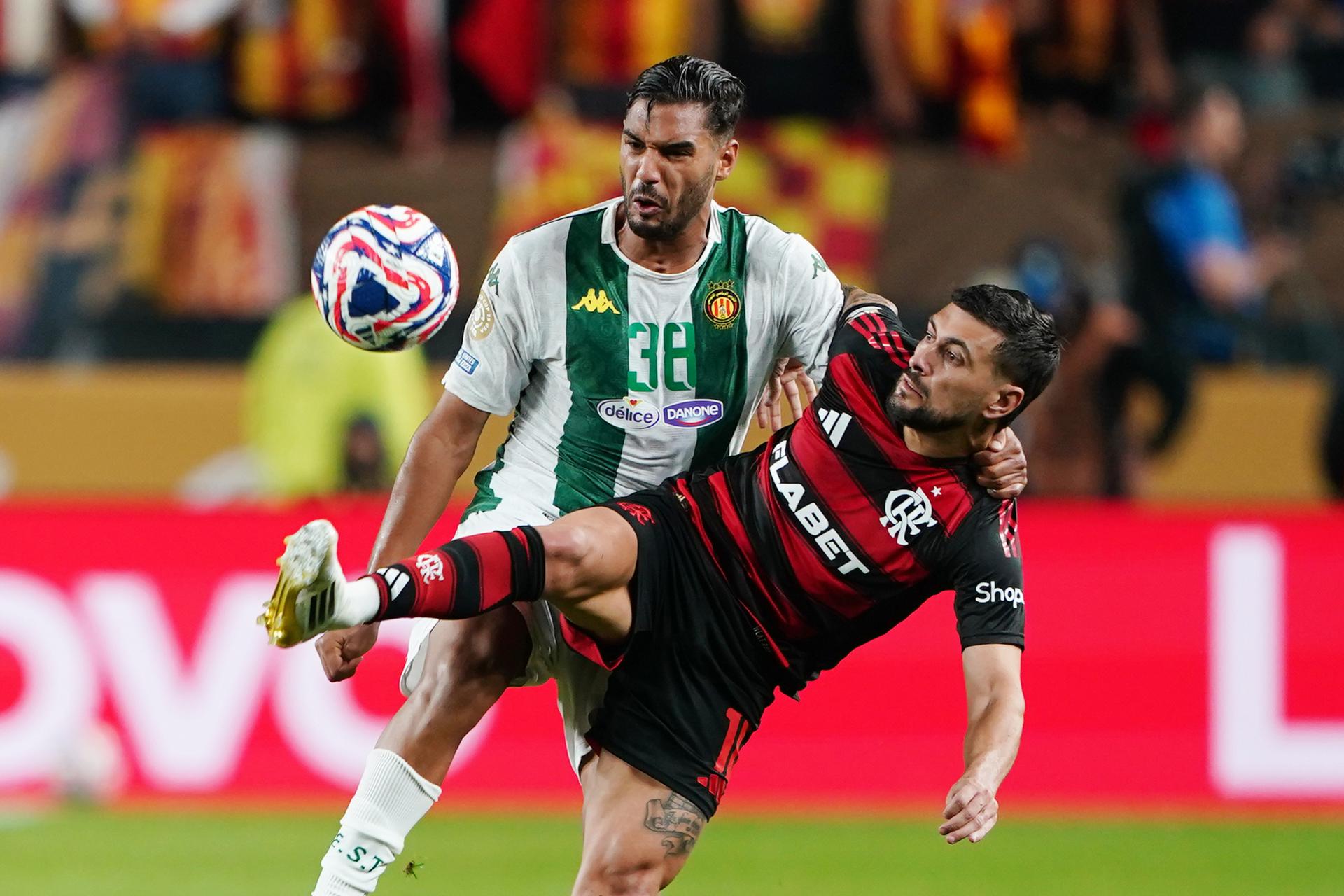 El creativo uruguayo de Flamengo, Giorgian de Arrascaeta (d), resiste la marca del defensor Khalil Guenichi de Esperánce Tunis (i) durante el partido del Mundial de Clubes que el equipo rojinegro brasileño ganó por 2-0 en Filadelfia. EFE/EPA/WILL OLIVER