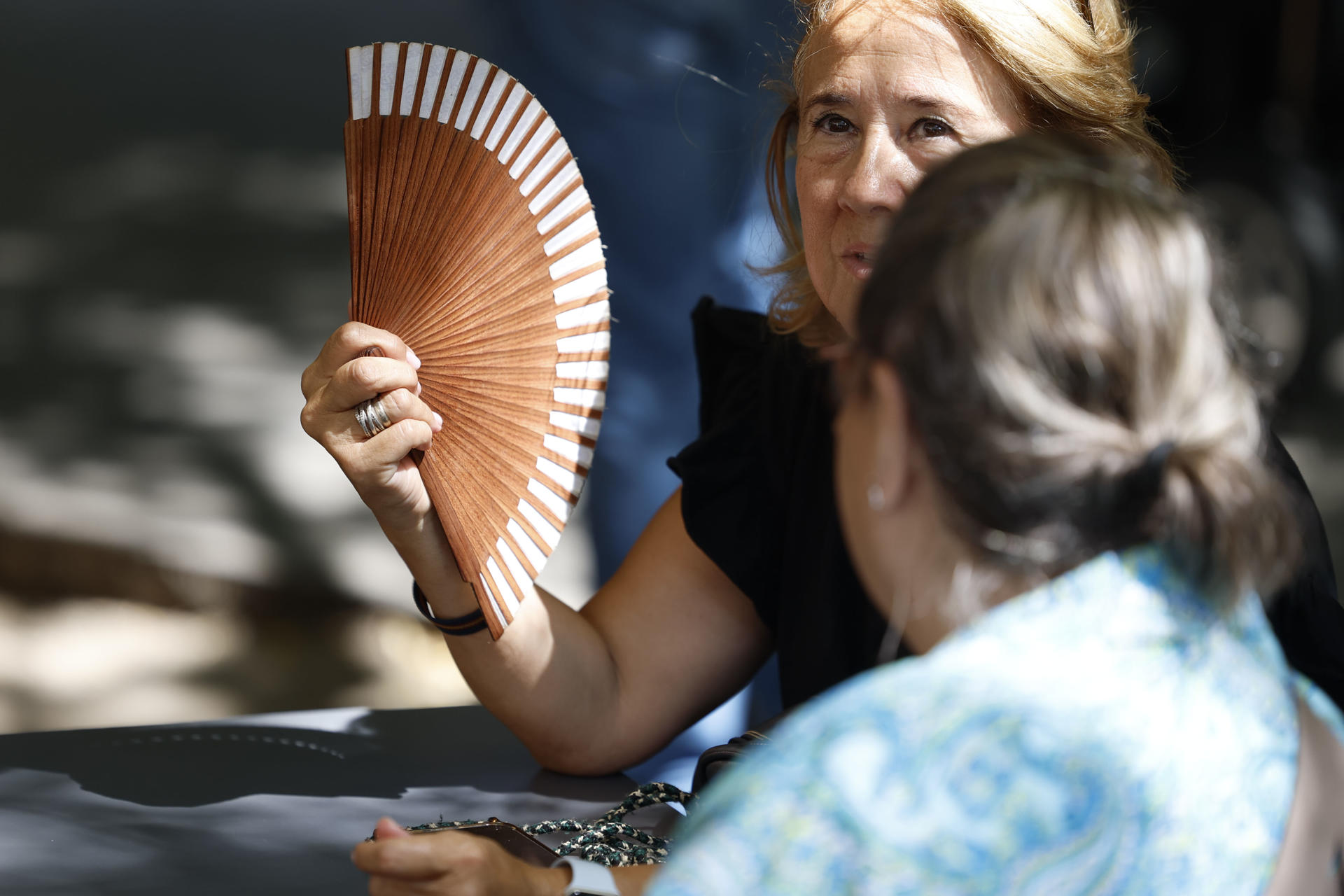 Una mujer se abanica para intentar mitigar las altas temperaturas que se registran este miércoles en Madrid.EFE/ Mariscal