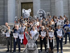 Miembros de varias organizaciones animalistas se han concentrado este miércoles frente al Congreso de los Diputados para exigir el fin de las jaulas en las granjas de la Unión Europea reclamando que la Comisión Europea cumpla "su compromiso" de prohibir progresivamente este sistema de cría. EFE/Lucía Pereda