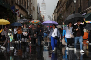 Personas se protegen de la lluvia con sombrillas este domingo, en Ciudad en México (México). EFE/ Isaac Esquivel